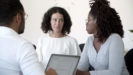 Excited-woman-talking-to-colleagues-during-meeting